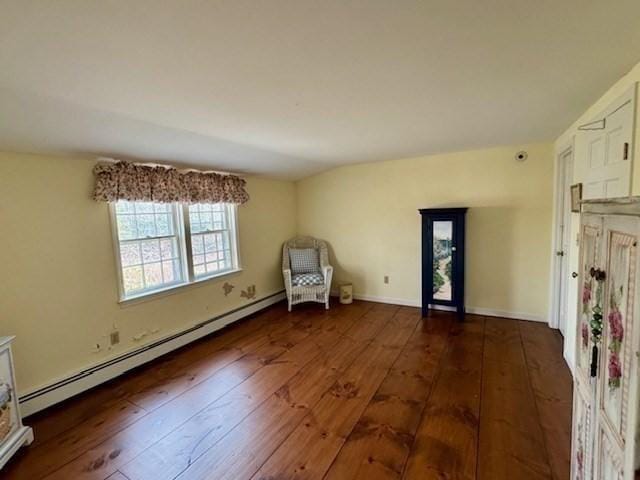 unfurnished room featuring baseboard heating and hardwood / wood-style flooring