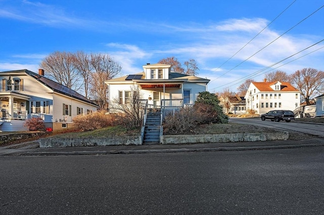 view of front of property featuring covered porch and solar panels