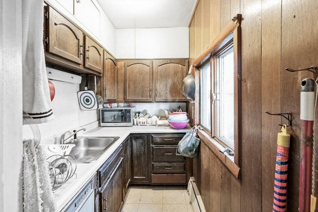 kitchen featuring wood walls, light tile patterned floors, sink, and a baseboard heating unit