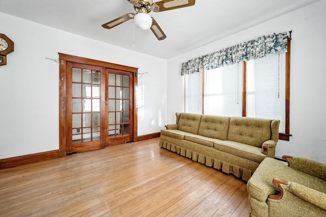 living room featuring light hardwood / wood-style floors, baseboard heating, and ceiling fan