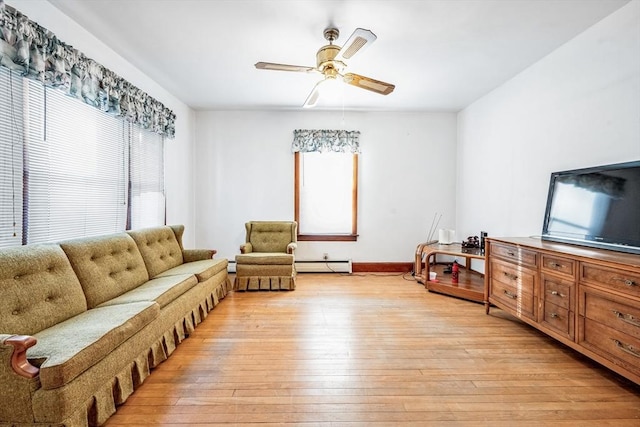 living area featuring ceiling fan, baseboard heating, and light hardwood / wood-style flooring