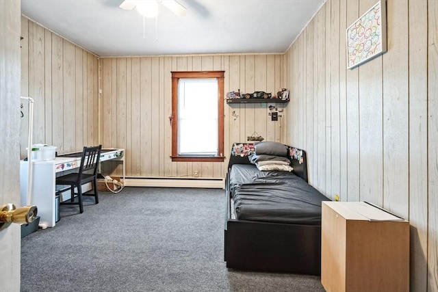 carpeted bedroom featuring baseboard heating, ceiling fan, and wood walls