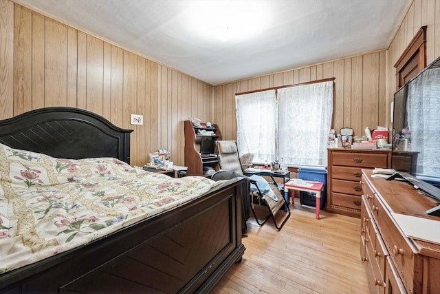 bedroom with wooden walls and light wood-type flooring