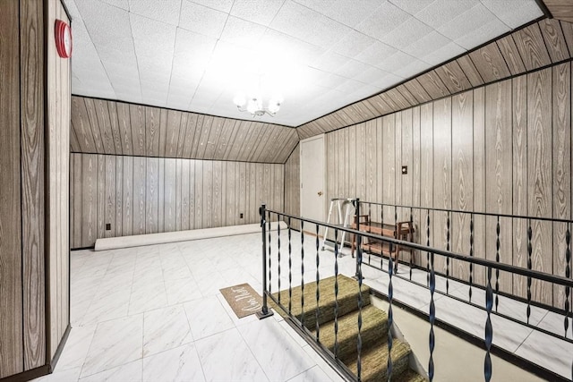 bonus room with vaulted ceiling and wood walls