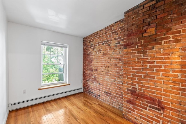 31 Division St # 3, Chelsea, MA 02150 - spare room with a baseboard heating unit, brick wall, and light wood-style flooring