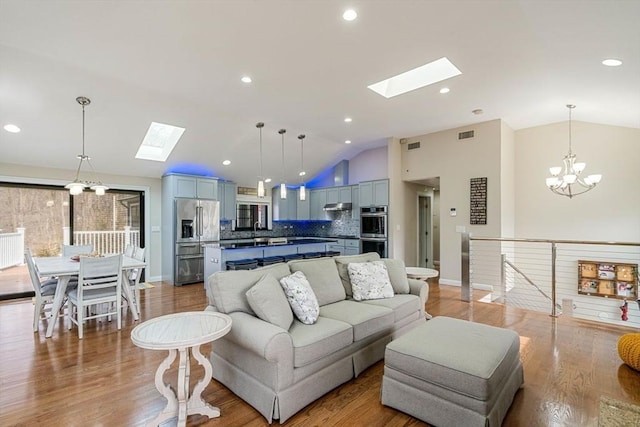 2171 Commonwealth Ave, Newton, MA 02466 - living room with a skylight, lofted ceiling, a chandelier, light wood-style flooring, and recessed lighting