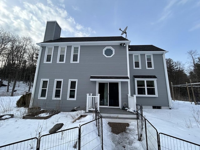 view of front of home with a chimney and fence