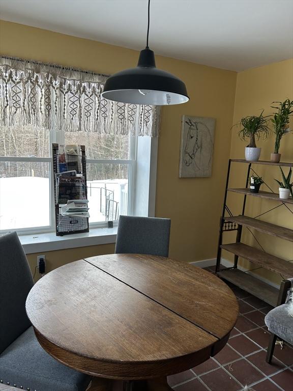 dining space featuring dark tile patterned flooring