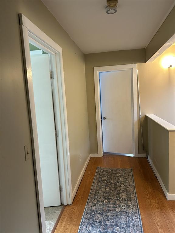 doorway to outside featuring wood finished floors and baseboards