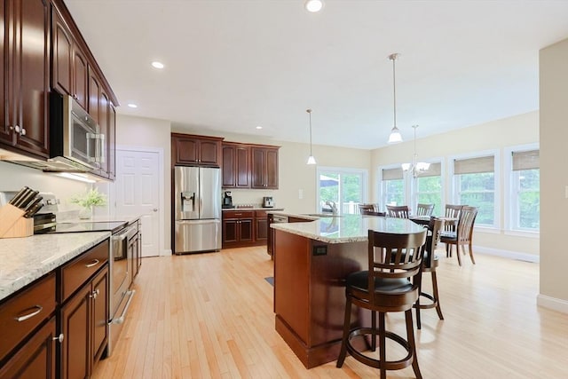 37 Sandy Ridge Rd, Sterling, MA 01564 - kitchen featuring appliances with stainless steel finishes, light wood finished floors, a breakfast bar area, a sink, and hanging light fixtures