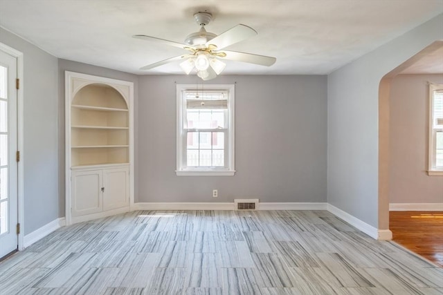 40 Fenimore Blvd, Springfield, MA 01108 - unfurnished room with arched walkways, light wood-style floors, a ceiling fan, and baseboards