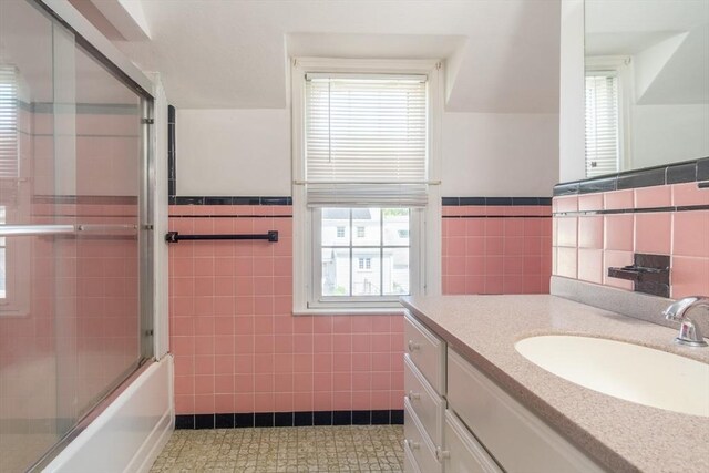 40 Fenimore Blvd, Springfield, MA 01108 - bathroom with tile walls, vanity, a wainscoted wall, and combined bath / shower with glass door