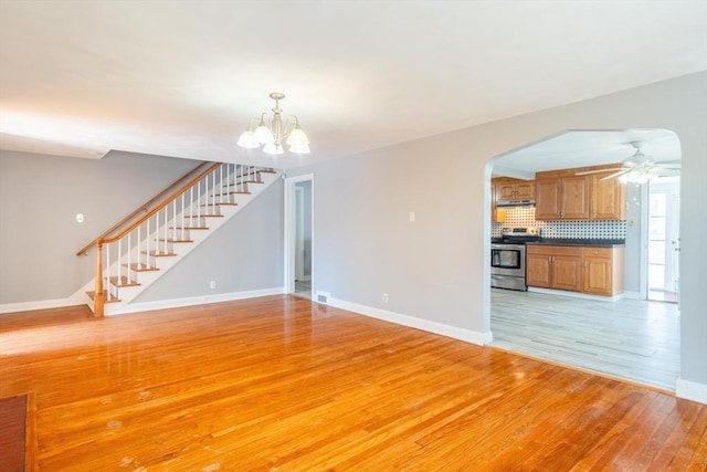 40 Fenimore Blvd, Springfield, MA 01108 - unfurnished living room with light wood-type flooring, baseboards, stairway, and a chandelier