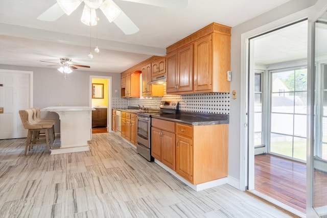 40 Fenimore Blvd, Springfield, MA 01108 - kitchen featuring stainless steel electric range oven, ceiling fan, under cabinet range hood, a breakfast bar area, and backsplash