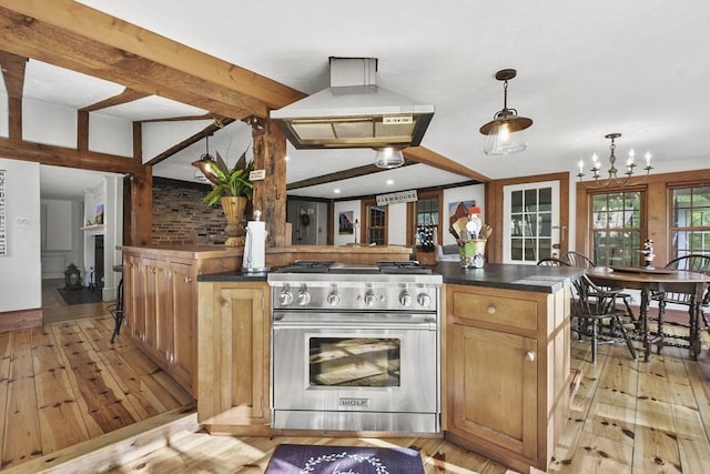 kitchen with dark countertops, high end range, exhaust hood, and light wood-type flooring