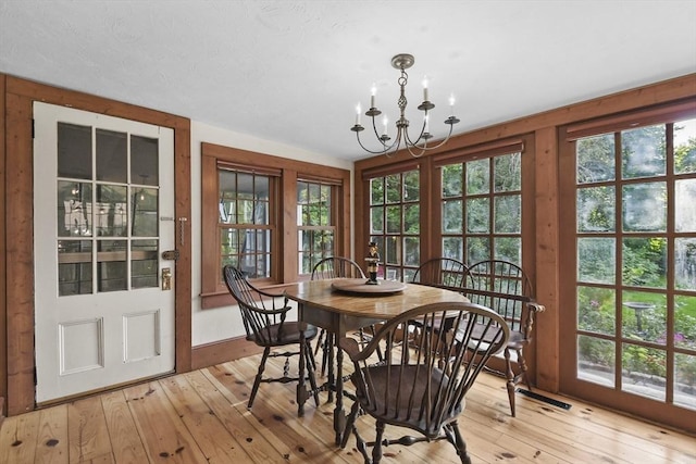 dining space with an inviting chandelier and light wood finished floors