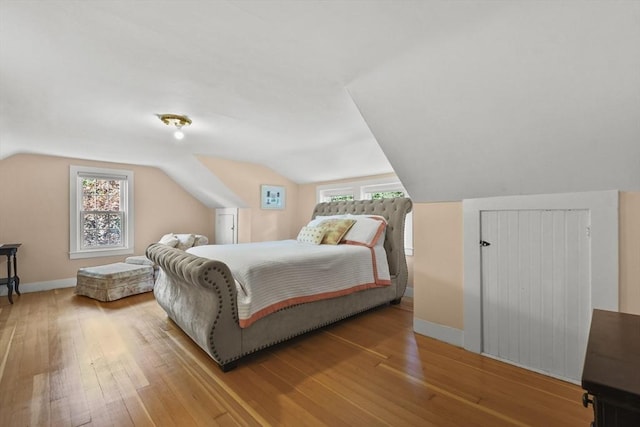 bedroom featuring baseboards, multiple windows, and hardwood / wood-style floors