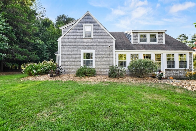 rear view of property featuring a lawn