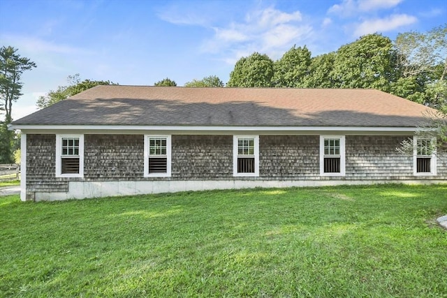 back of house with a lawn and a shingled roof