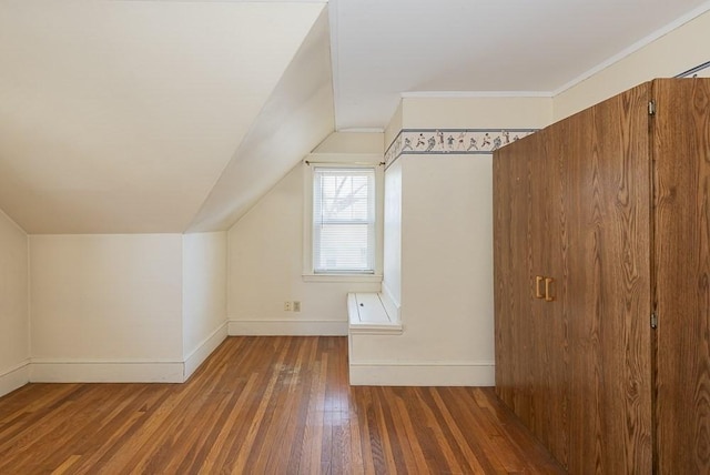 additional living space with baseboards, vaulted ceiling, and hardwood / wood-style floors