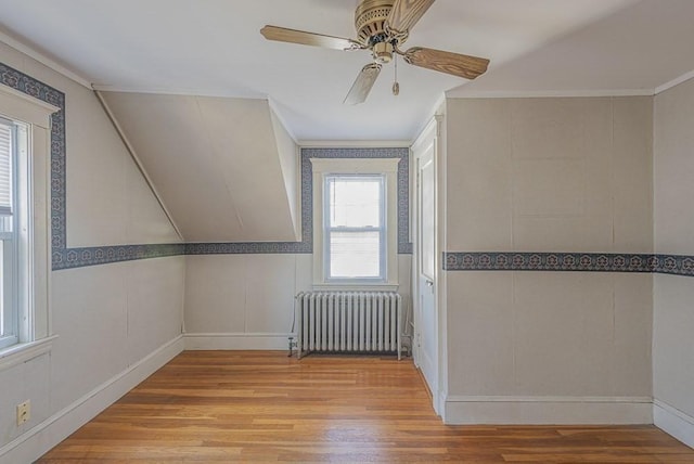 bonus room featuring ceiling fan, radiator heating unit, and wood finished floors