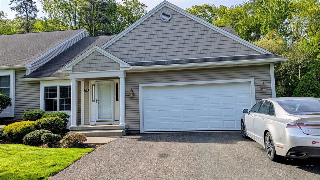 view of front facade featuring asphalt driveway, an attached garage, and roof with shingles
