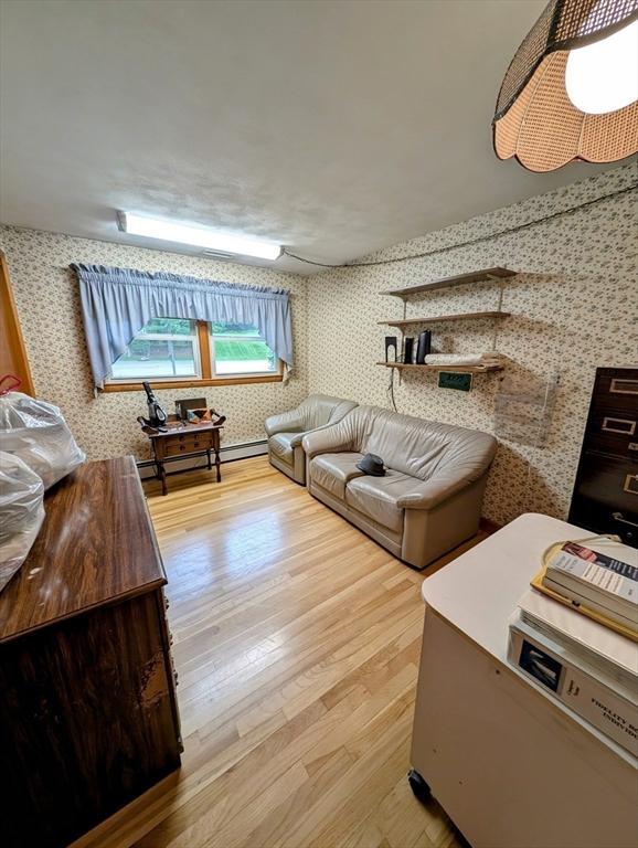 17 Laurel Dr, Millbury, MA 01527 - living area with wallpapered walls, wood finished floors, and a baseboard heating unit