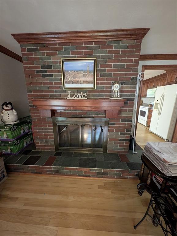 17 Laurel Dr, Millbury, MA 01527 - detailed view of white appliances, wood finished floors, ornamental molding, and a fireplace