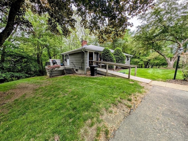 17 Laurel Dr, Millbury, MA 01527 - view of front of house featuring a wooden deck, a chimney, a front yard, and driveway