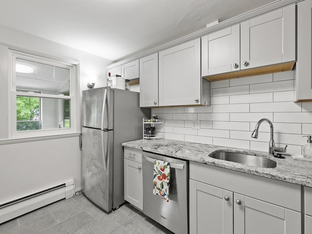 14 Riverside Dr, North Reading, MA 01864 - kitchen featuring stainless steel appliances, baseboard heating, a sink, decorative backsplash, and light stone counters