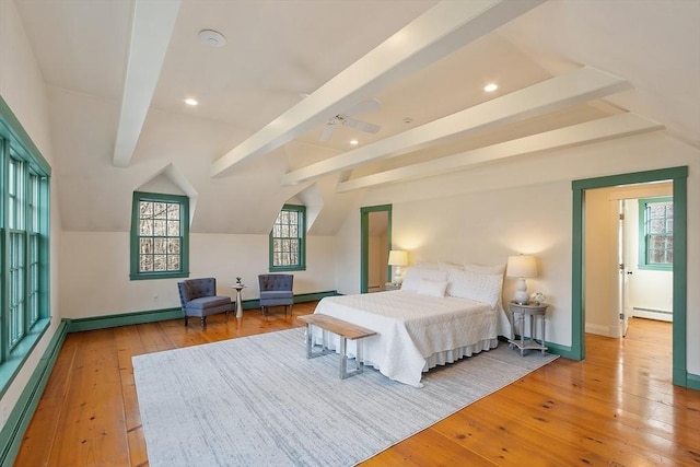 bedroom with light wood-style flooring, vaulted ceiling with beams, a baseboard heating unit, and a baseboard radiator