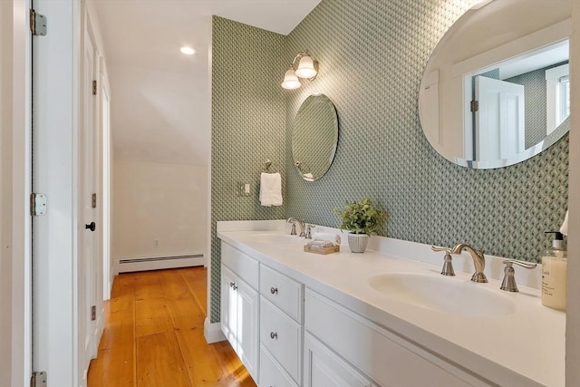 full bathroom with a sink, a baseboard heating unit, and wallpapered walls