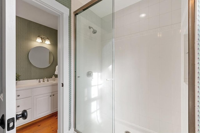 bathroom with vanity, a shower stall, and wood finished floors