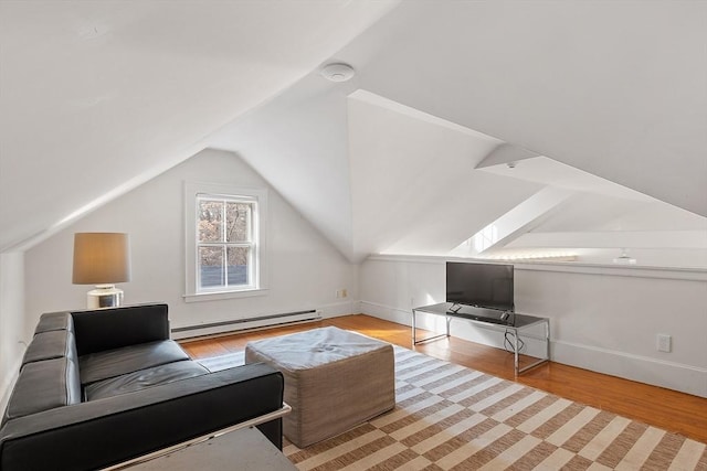 bonus room with a baseboard heating unit, lofted ceiling, wood finished floors, and baseboards