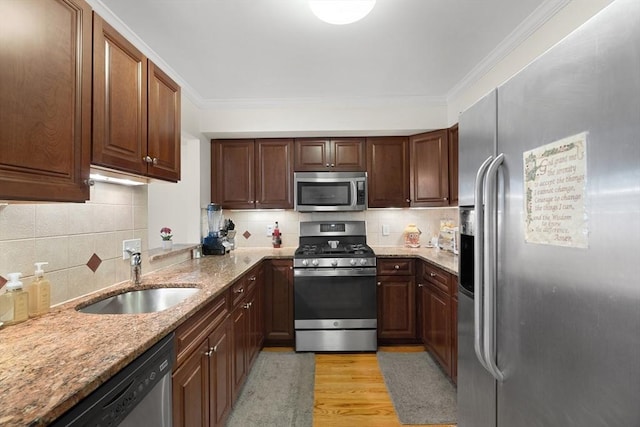2826 Washington St, Boston, MA 02119 - kitchen featuring appliances with stainless steel finishes, a sink, decorative backsplash, light stone countertops, and light wood-style flooring