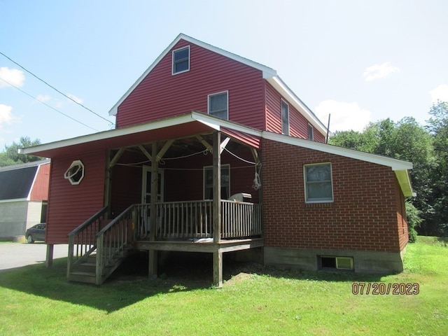 rear view of property with a yard and covered porch