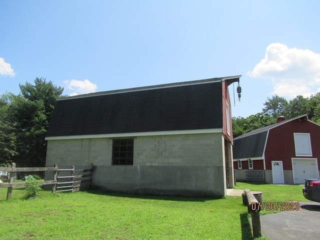 view of home's exterior with an outdoor structure and a lawn