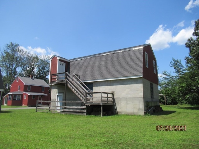 back of property with a yard and a wooden deck