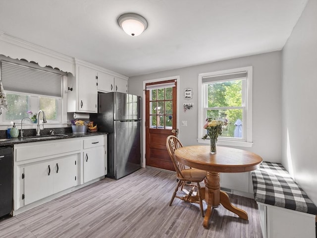 20 Dunshire Dr, Chelmsford, MA 01863 - kitchen featuring freestanding refrigerator, dark countertops, light wood-style flooring, white cabinets, and dishwasher
