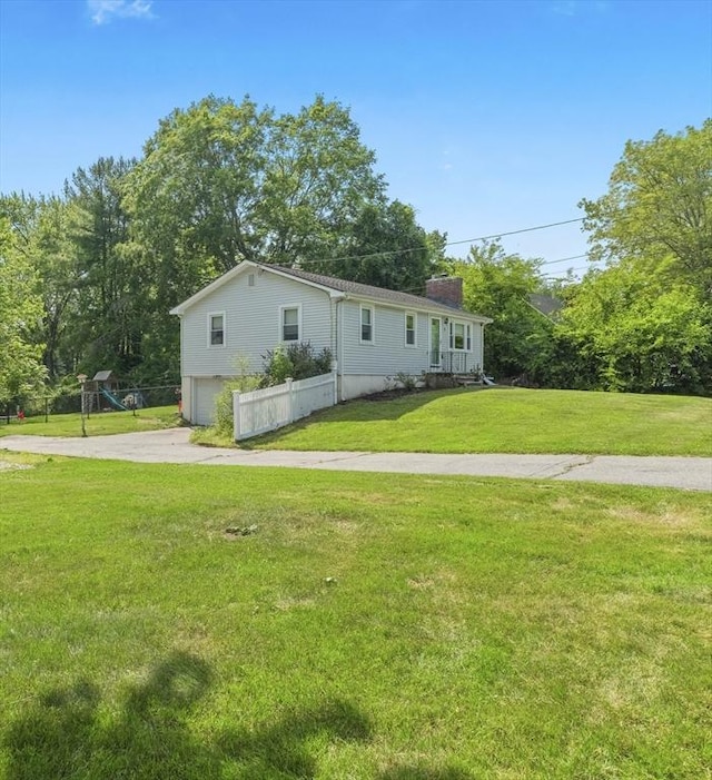 20 Dunshire Dr, Chelmsford, MA 01863 - view of front facade featuring a chimney, concrete driveway, a garage, and a front yard