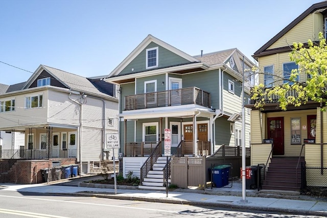 view of front of house featuring covered porch, stairway, and a balcony