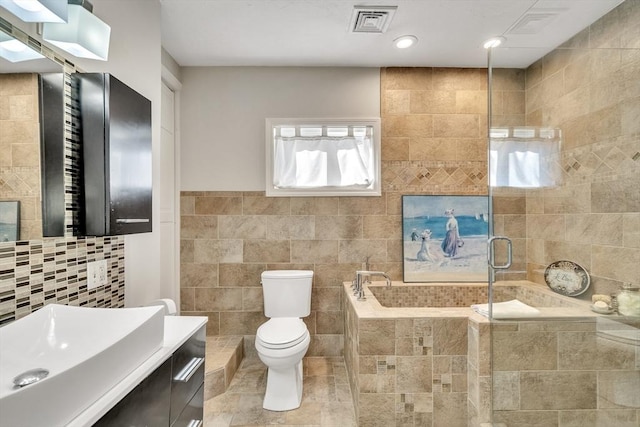 bathroom featuring toilet, tile walls, tiled shower, and a garden tub
