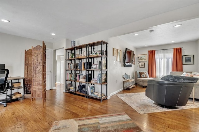 living area with baseboards, recessed lighting, and wood finished floors
