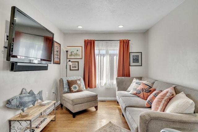 living area with light wood-style floors, baseboards, and recessed lighting
