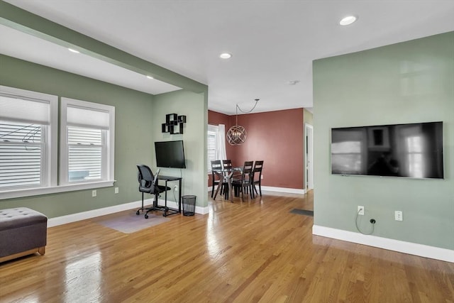 living room with recessed lighting, baseboards, a chandelier, and light wood-style floors