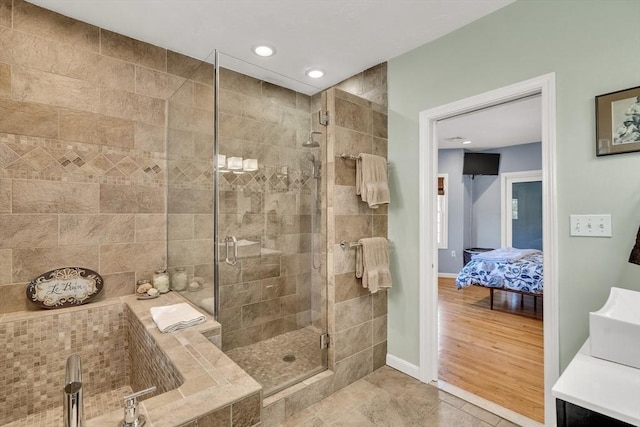 ensuite bathroom with baseboards, recessed lighting, connected bathroom, a bath, and a shower stall
