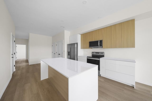 546 Saratoga Unit 1, Boston, MA 02128 - kitchen with appliances with stainless steel finishes, wood finished floors, modern cabinets, a kitchen island, and light countertops