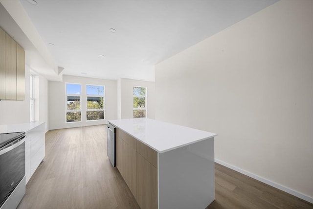 546 Saratoga Unit 1, Boston, MA 02128 - kitchen featuring modern cabinets, stainless steel appliances, light wood-style floors, a center island, and light countertops