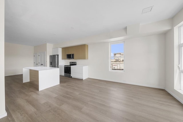 546 Saratoga Unit 1, Boston, MA 02128 - unfurnished living room with light wood-style floors, healthy amount of natural light, and baseboards
