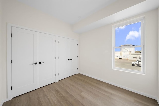 546 Saratoga Unit 1, Boston, MA 02128 - unfurnished bedroom with multiple closets, wood finished floors, and baseboards